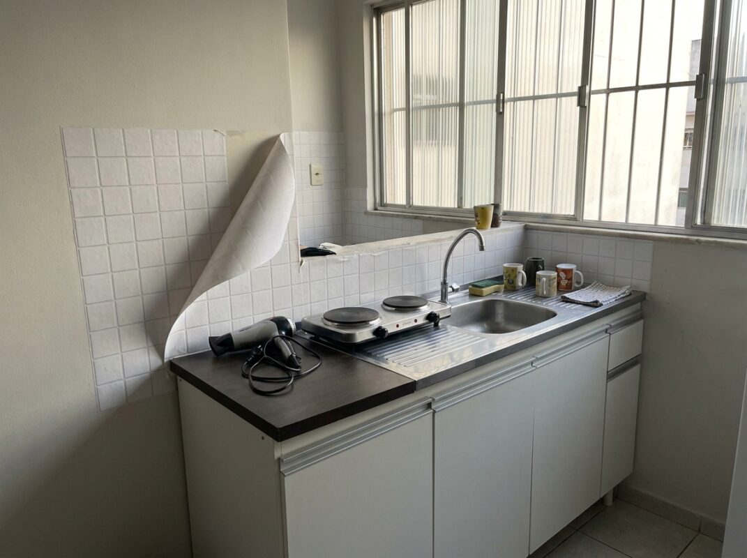 Cozinha de apartamento alugado com adesivo de azulejo na parede da pia